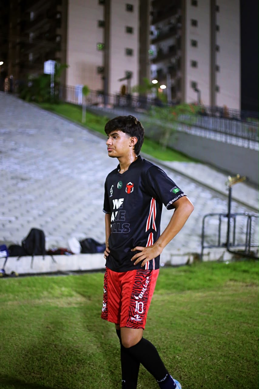 Portrait of Zavyan Haider in a black football kit on the pitch